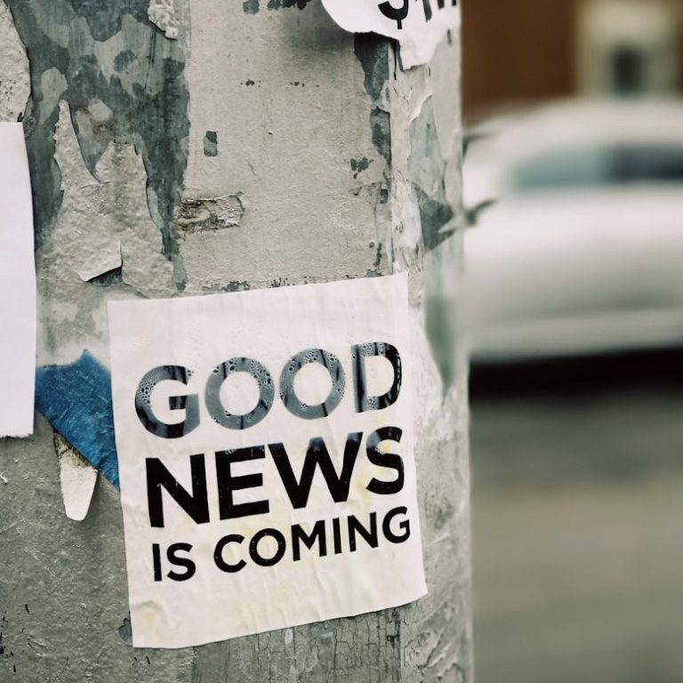 Texte erstellen lassen mit wortgenauer Abrechnung Auf einem Pfeiler klebt ein Aufkleber mit der Aufschrift "GOOD NEWS IS COMING". Die Abrechnung hier erfolgt wortgenau!